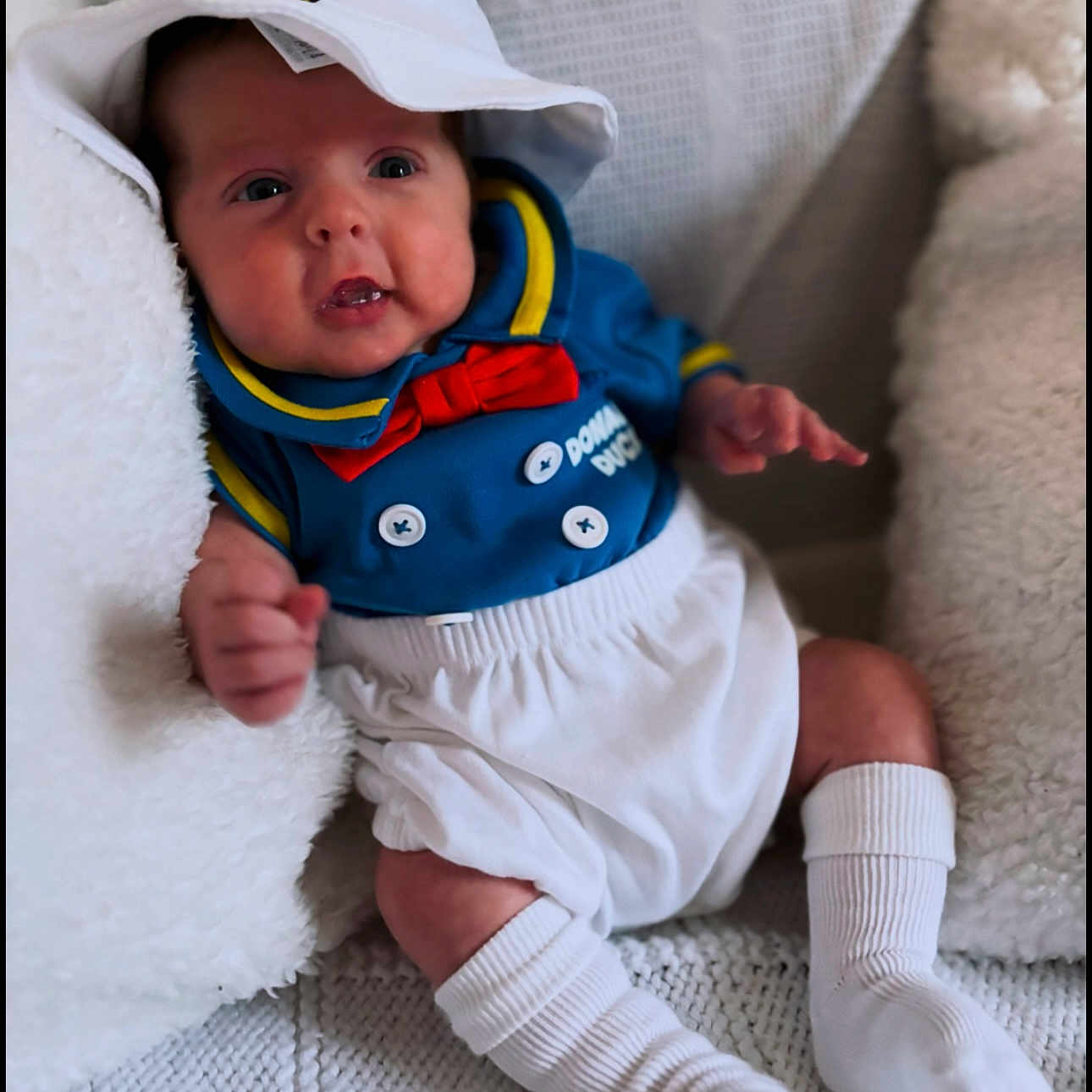 Kodie joined the competition — help win amazing prizes! baby, bodypart, bonnet, cap, clothing, couch, face, finger, furniture, hand, happy, hat, head, hosiery, person, photography, portrait, sitting, smile, sock