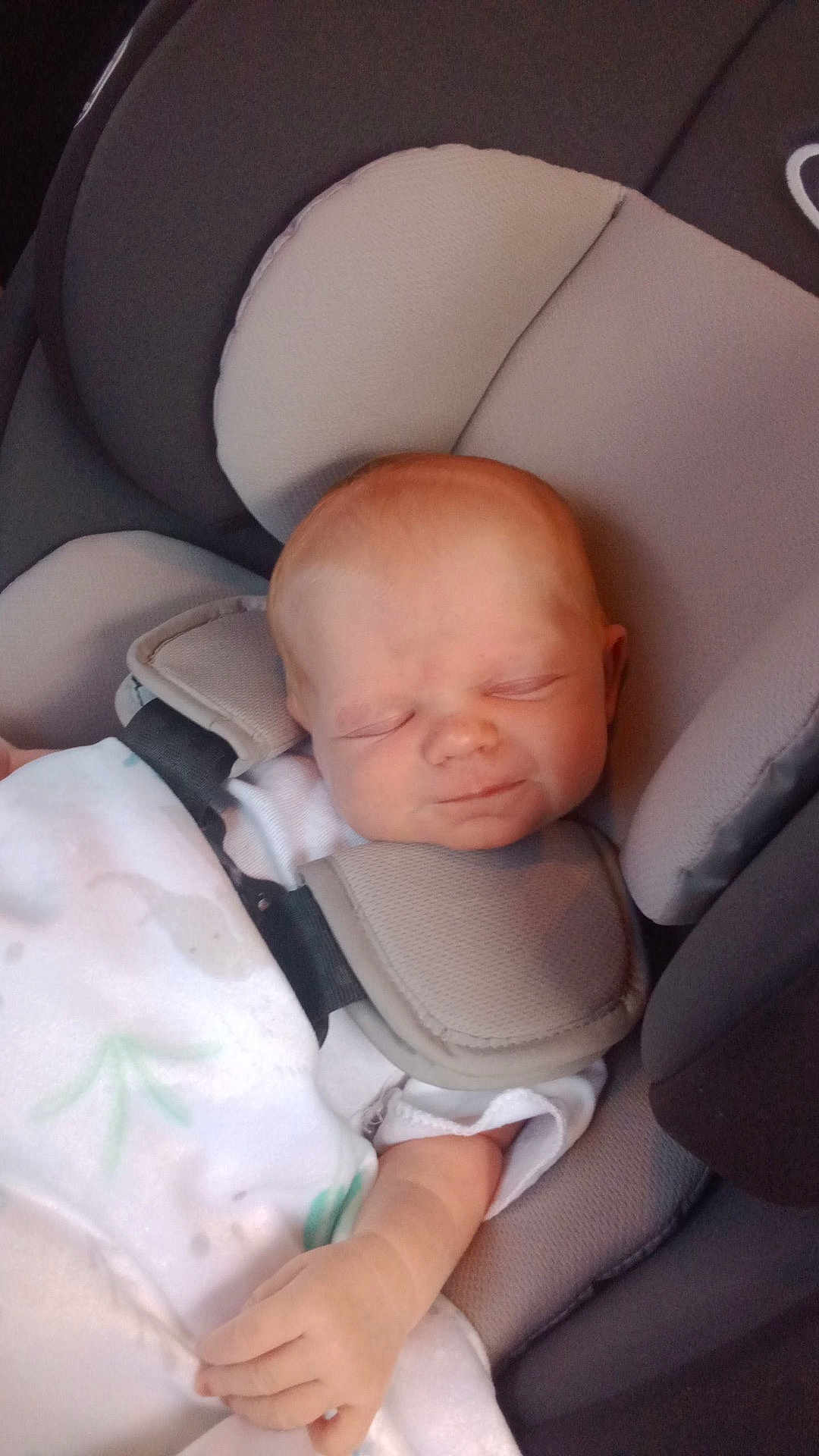 Esther is registered to the contest to win money with this photo: baby, sleeping, car_seat, blanket, infant, child, cushion, seatbelt, resting, peaceful, young, hand, face, head, clothing, comfort, indoors, transport, portrait, toddler