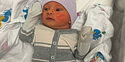Maximus is registered to the contest to win money with this photo: baby, bassinet, blanket, child, clothing, crib, cute, face, hat, hospital, indoors, infant, lying_down, newborn, newborn_care, onesie, pacifier, person, sleepwear, soft