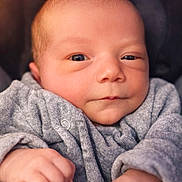 Youna participe au concours pour gagner de l'argent avec cette photo : baby, child, close_up, cozy, cute, expression, face, gray_clothing, hands, human, indoor, infant, newborn, peaceful, portrait, skin, small_fingers, soft_texture, warm, young