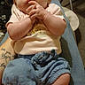 Rose is registered to the contest to win money with this photo: baby, infant, child, portrait, indoor, sitting, bow, headband, pink_clothing, blue_shorts, sandals, hands, face, looking_at_camera, brown_hair, fair_skin, chair, adult_lap, home, casual_photo