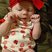 Rose joined the competition — help win amazing prizes! newborn, baby, infant, sleeping, portrait, close_up, red_bow, headband, onesie, ladybugs, flowers, patterned_clothing, fists, hands, face, indoors, blanket, camouflage, sitting, peaceful