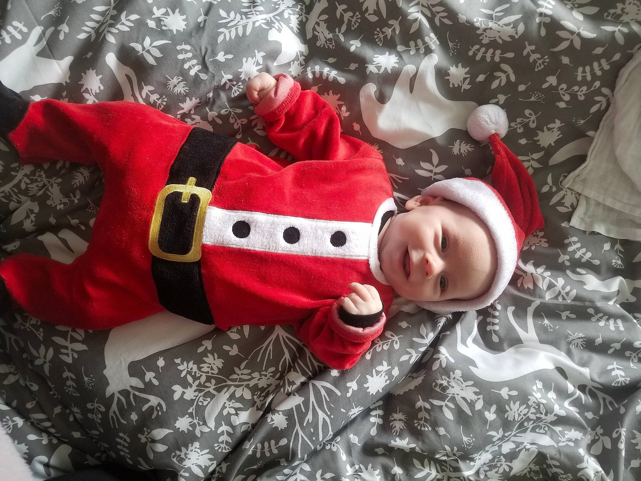 Théo participe au concours pour gagner de l'argent avec cette photo : baby, baby_toddler_clothing, carmine, child, christmas, christmas_decoration, christmas_eve, christmas_ornament, event, fictional_character, happy, headwear, holiday, linens, outerwear, person, sleeve, smile, textile, toddler