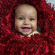 Gabriella joined the competition — help win amazing prizes! baby, celebration, cheerful, closeup, cute, decoration, expression, face, festive, happy, head, holiday, infant, joyful, portrait, red, shiny, smiling, sparkling, tinsel