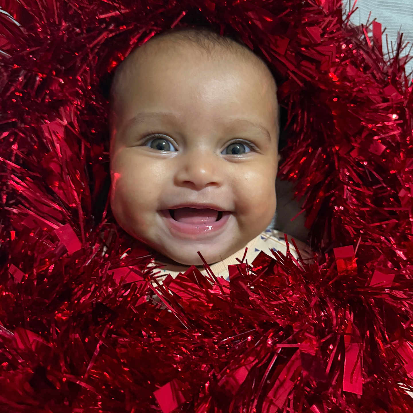 Gabriella joined the competition — help win amazing prizes! baby, celebration, cheerful, closeup, cute, decoration, expression, face, festive, happy, head, holiday, infant, joyful, portrait, red, shiny, smiling, sparkling, tinsel