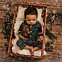 Dakari joined the competition — help win amazing prizes! baby, sleeping, plush_toy, wooden_cradle, pajamas, holiday, christmas, pine_cones, berries, greenery, floor, wood, cozy, infant, child, cute, indoors, soft_fur, festive, winter