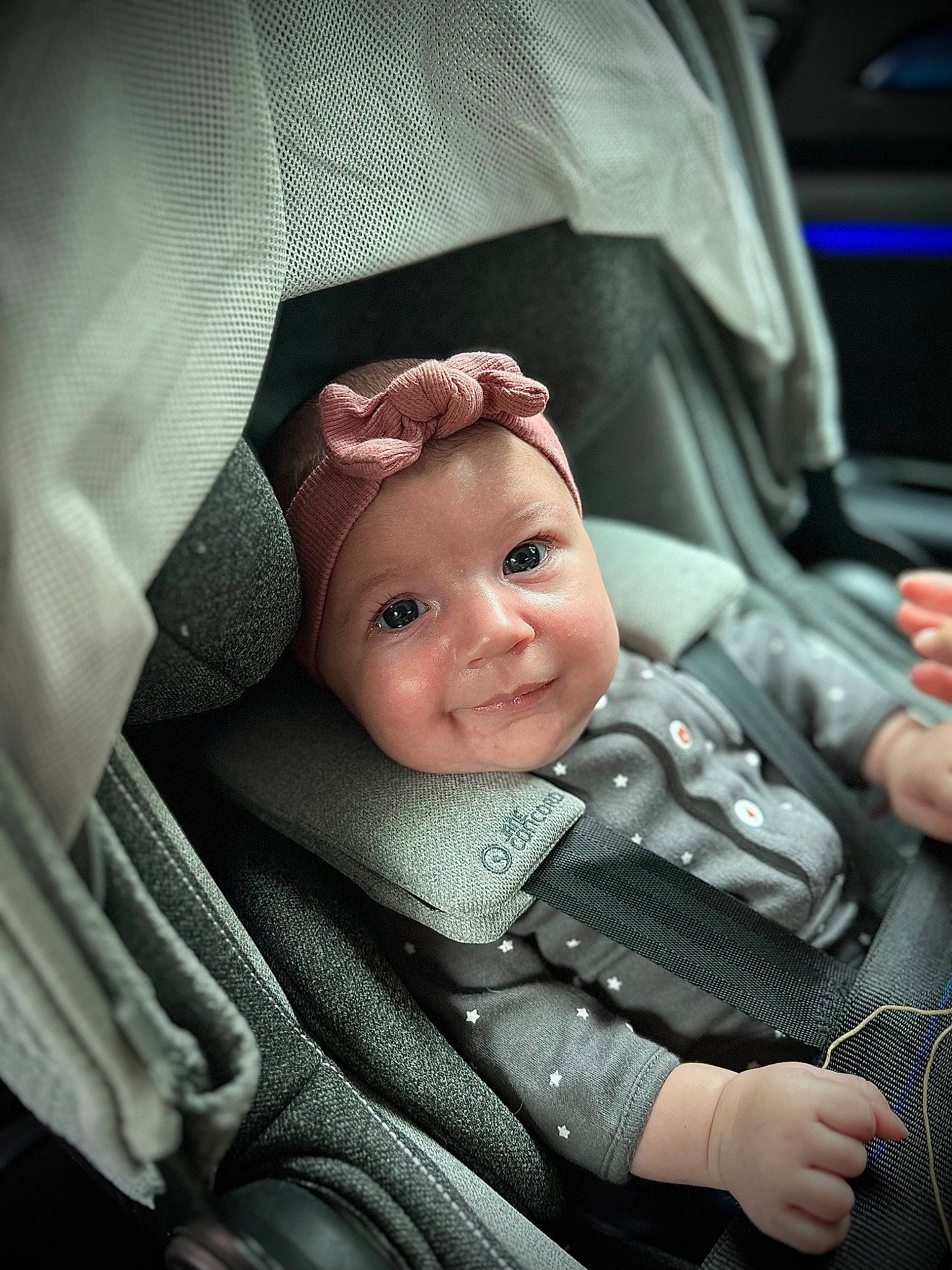 Lia a rejoint le concours — aidez-le/la à gagner de superbes lots ! auto_part, baby, baby_carriage, baby_products, car_seat, cheek, comfort, eyebrow, facial_expression, finger, gesture, hand, headgear, headwear, mouth, person, seat_belt, skin, smile, toddler