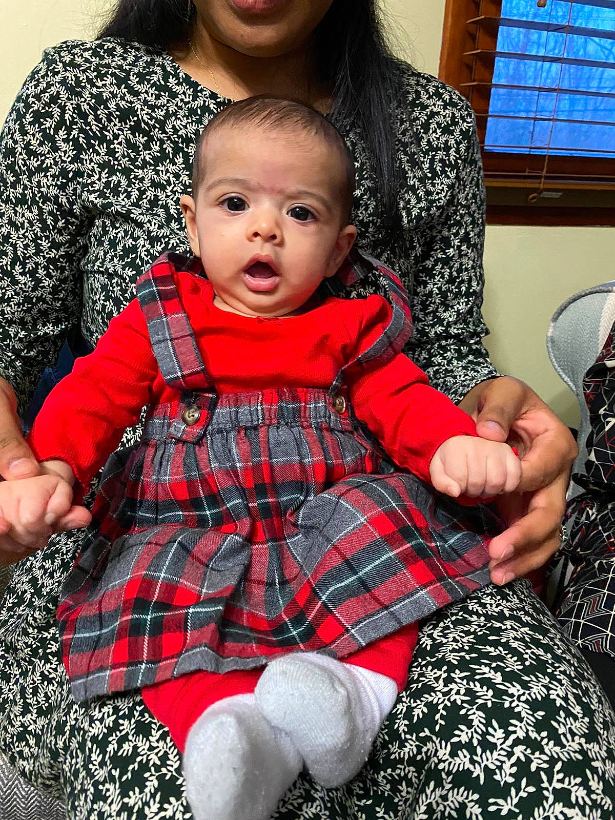 Ariana is registered to the contest to win money with this photo: baby, baby_toddler_clothing, beauty, black, child, dress, face, fashion, happy, iris, lap, organ, pattern, person, plaid, sitting, skin, sleeve, sock, surprise