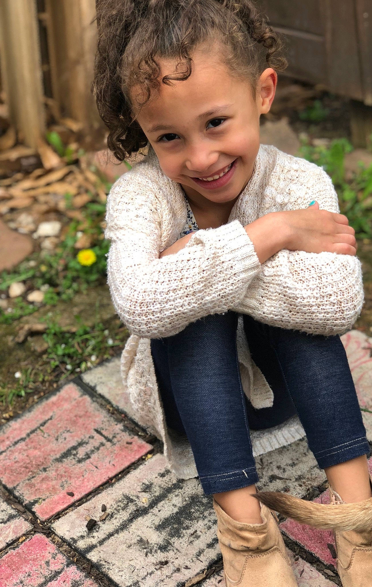 Tatum is registered to the contest to win money with this photo: beauty, cheek, child, child_model, footwear, fun, grass, jeans, joy, knitting, leg, outerwear, person, photography, sitting, smile, toddler, wool