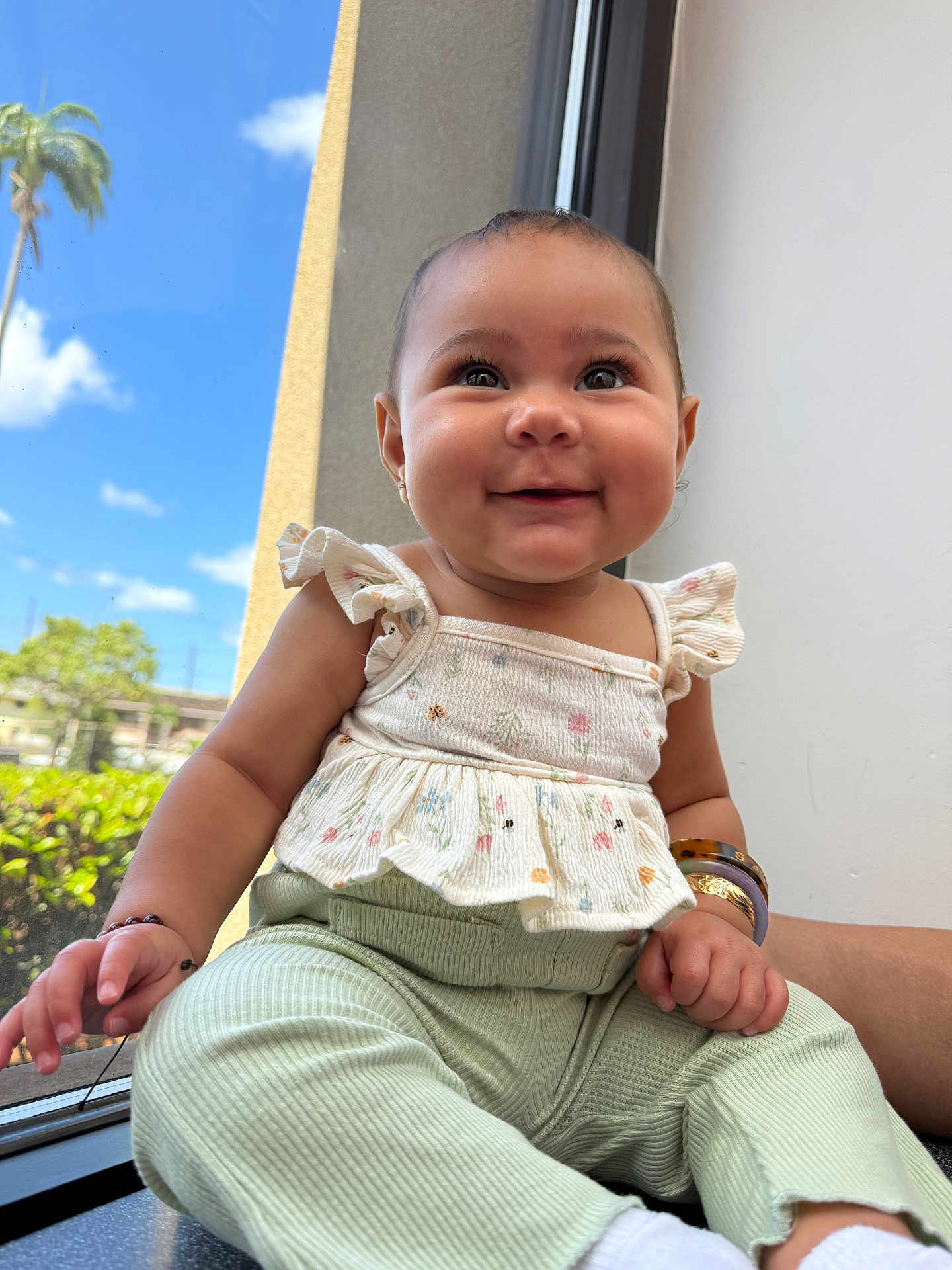 Zaileigh joined the competition — help win amazing prizes! baby, child, smiling, window, outdoor, sunlight, clothing, pants, top, bracelet, earrings, hand, face, person, cute, happy, sitting, infant, green, white