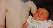 Sebastian is registered to the contest to win money with this photo: child, baby, siblings, brother, newborn, infant, portrait, smiling, sleeping, cuddling, sitting, indoors, couch, family, bare_chested, diaper, onesie, pink_clothing, warm_lighting, photograph