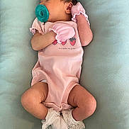 Dolores is registered to the contest to win money with this photo: baby, baby_clothing, child, closeup, cute, frills, human, indoors, infant, mittens, newborn, pacifier, peaceful, pink_onesie, portrait, resting, sleeping, socks, soft_surface, tiny