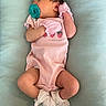 baby, baby_clothing, child, closeup, cute, frills, human, indoors, infant, mittens, newborn, pacifier, peaceful, pink_onesie, portrait, resting, sleeping, socks, soft_surface, tiny