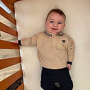 Lushenzo participe au concours pour gagner de l'argent avec cette photo : baby, infant, crib, mattress, sweater, collar, pants, socks, smile, happy, face, eyes, hair, hand, wooden_slats, portrait, indoor, bedding, cute, lying_down