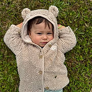 Noélio participe au concours pour gagner de l'argent avec cette photo : baby, child, hoodie, bear_ears, grass, outdoor, cute, smile, face, clothing, nature, greenery, portrait, cozy, infant, lying_down, casual, playful, young_child, cute_expression