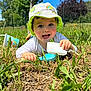 toddler, child, baby, grass, outdoor, sunhat, hat, shovel, blue_scoop, greenery, sky, daylight, play, happy, smiling, nature, grass_field, summer, toy, person