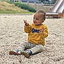 casual_clothing, child, curious, daylight, exploration, expression, fun, happy, nature, outdoor, pebbles, playground, playing, shoes, sitting, slide, smiling, toddler, yellow_sweater, young_child