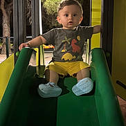 Elisëo a rejoint le concours — aidez-le/la à gagner de superbes lots ! toddler, child, slide, playground, night, outdoor, green, yellow, shoes, shorts, tshirt, trees, fence, play, fun, expression, curious, person, baby, park