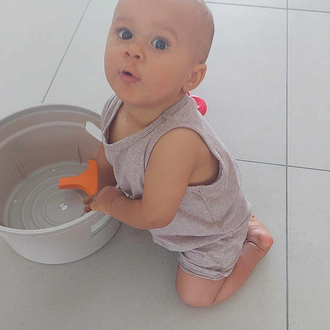 Aaron a rejoint le concours — aidez-le/la à gagner de superbes lots ! baby, bucket, child, clothing, curious, expression, floor, home, indoor, kneeling, light, person, plastic, play, shorts, skin, sleeveless_shirt, tile, toddler, toy