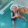 toddler, child, smiling, hat, bottle, tent, outdoor, play, happy, sitting, clothing, sunhat, baby, plastic_bottle, fabric, green, blue, summer, daylight, fun