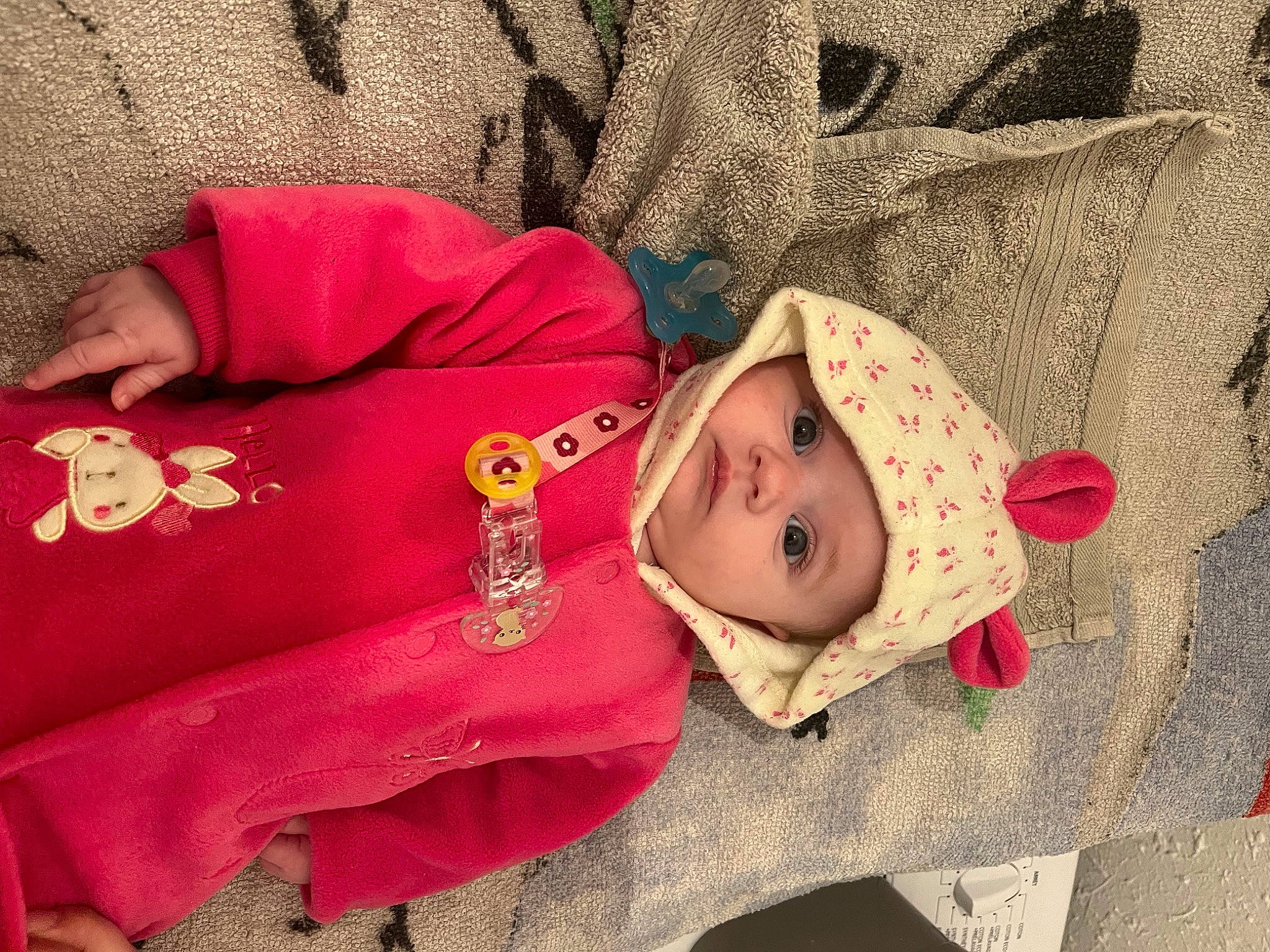 Lola participe au concours pour gagner de l'argent avec cette photo : baby, baby_toddler_clothing, carmine, cheek, child, comfort, eye, face, happy, head, headwear, human_body, linens, mammal, outerwear, pattern, person, skin, sleeve, textile