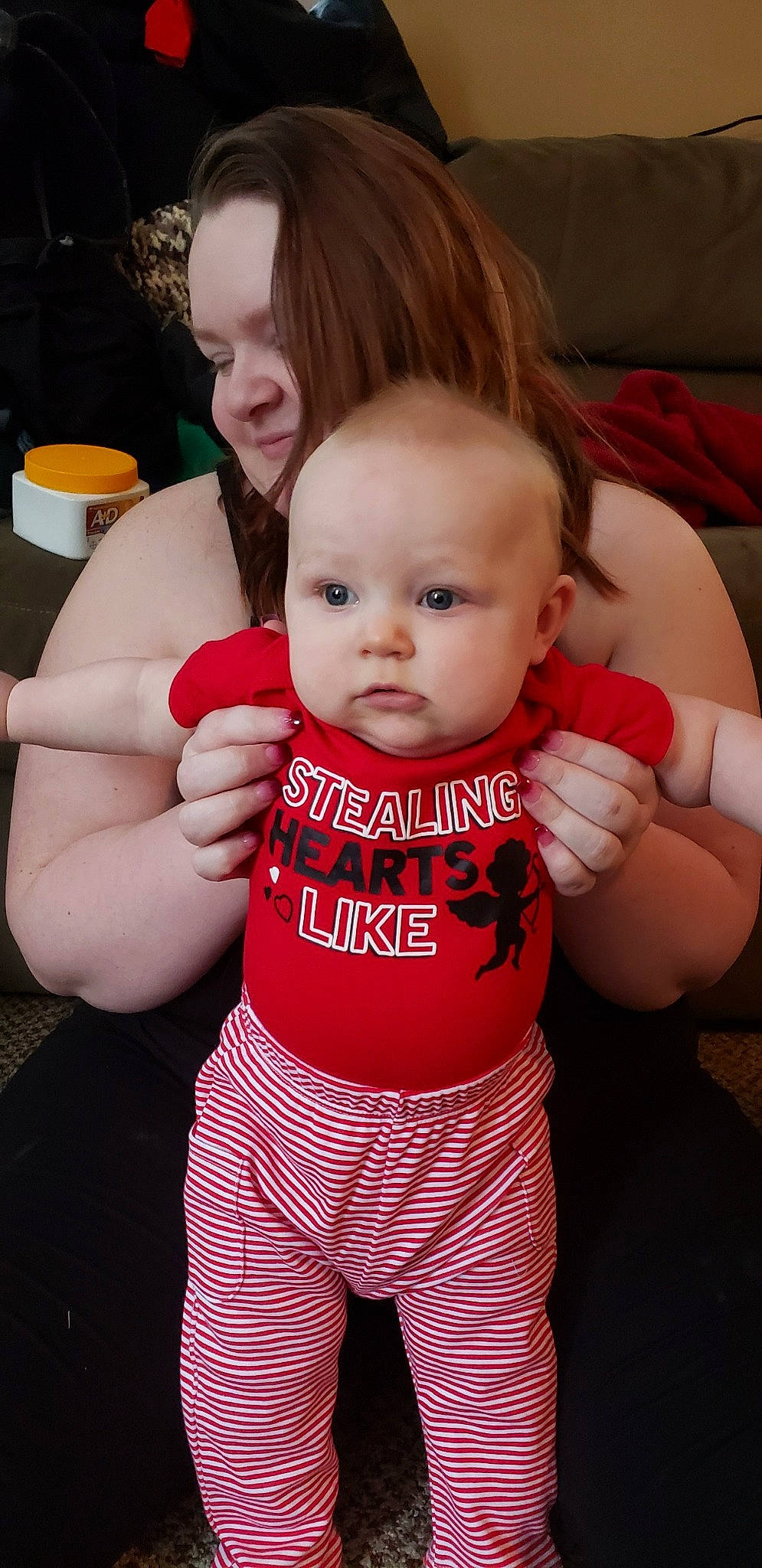 Oliver is registered to the contest to win money with this photo: baby, baby_toddler_clothing, cheek, drinkware, face, finger, gesture, hair, hairstyle, hand, happy, head, human_body, lip, neck, person, pink, skin, sleeve, thigh