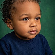 Joao Julian joined the competition — help win amazing prizes! child, toddler, curly_hair, blue_sweater, portrait, studio, green_background, cute, thoughtful, face, skin, eyes, hands, clothing, fashion, young_child, person, indoors, expression, innocence