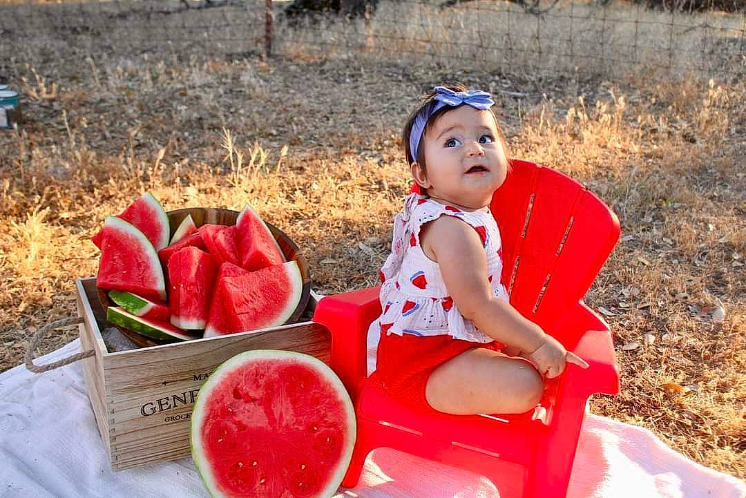 Katerina is registered to the contest to win money with this photo: citrullus, dress, fruit, fun, grass, happy, hat, headwear, ingredient, leisure, melon, natural_foods, people_in_nature, person, plate, produce, public_space, recreation, superfood, tableware