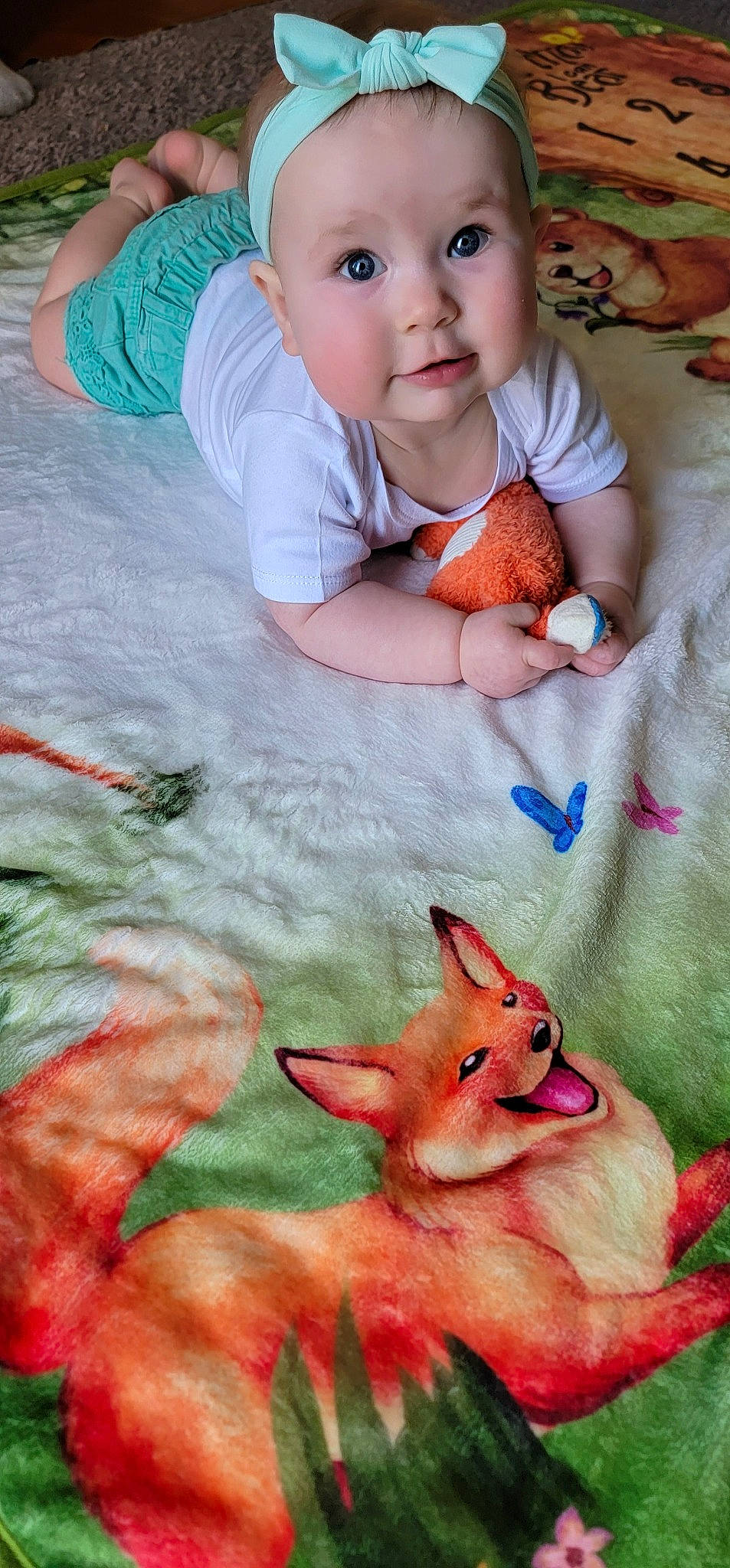 Megan is registered to the contest to win money with this photo: art, baby, baby_toddler_clothing, blue, child, finger, grass, happy, insect, linens, mammal, mouth, nail, pattern, person, pink, skin, textile, thumb, toddler