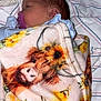 newborn, baby, blanket, pacifier, face, infant, bed, striped_sheet, baby_wipes, soft_toy, sleeping, wrapped, cute, animal_print, sunflower, closeup, indoors, child, portrait, resting