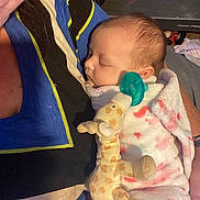 Brynleigh joined the competition — help win amazing prizes! baby, sleeping, blanket, plush_toy, giraffe, pacifier, adult, holding, cozy, soft, comfort, indoor, clothing, person, child, infant, rest, cute, peaceful, portrait
