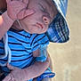 baby, sleeping, hat, blue_striped_clothing, pacifier, hand, infant, peaceful, outdoor, sunlight, cute, child, closeup, skin, person, young, resting, wearing, holding, adorable