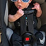 baby, sunglasses, car_seat, black_clothing, nike_shoes, hand_gesture, infant, seatbelt, toy, orange_toy, indoor, footwear, cute, child, young, person, black_pants, expression, head, hair