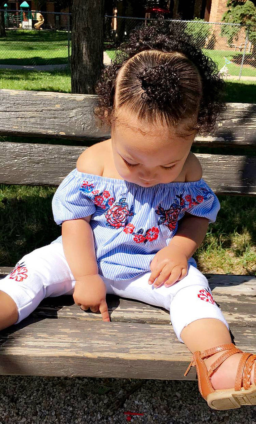 Lily is registered to the contest to win money with this photo: baby_toddler_clothing, child, denim, electric_blue, fun, grass, happy, human_leg, knee, leg, leisure, person, plant, public_space, sleeve, sock, sportswear, t_shirt, thigh, toddler