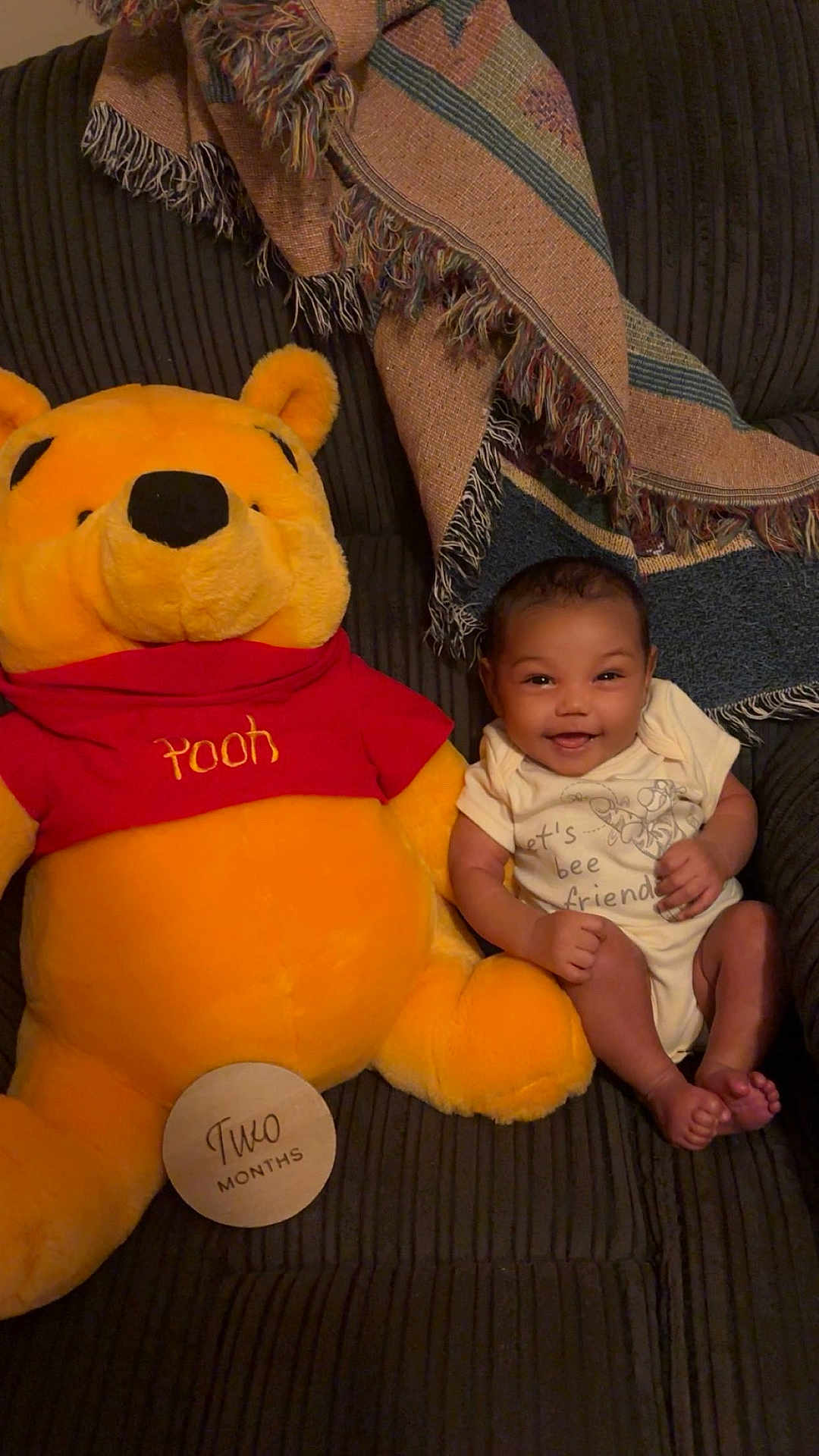Sequoia is registered to the contest to win money with this photo: baby, infant, plush_toy, winnie_the_pooh, stuffed_animal, couch, blanket, smile, happy, child, clothing, indoor, person, seated, cute, soft_toy, home, cozy, two_months, portrait