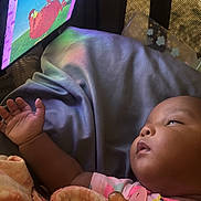 Miracle joined the competition — help win amazing prizes! baby, blanket, pacifier, cartoon, screen, indoor, child, sleepy, soft_lighting, cozy, fabric, hand, clothing, infant, toy, colorful, resting, person, closeup, relaxation