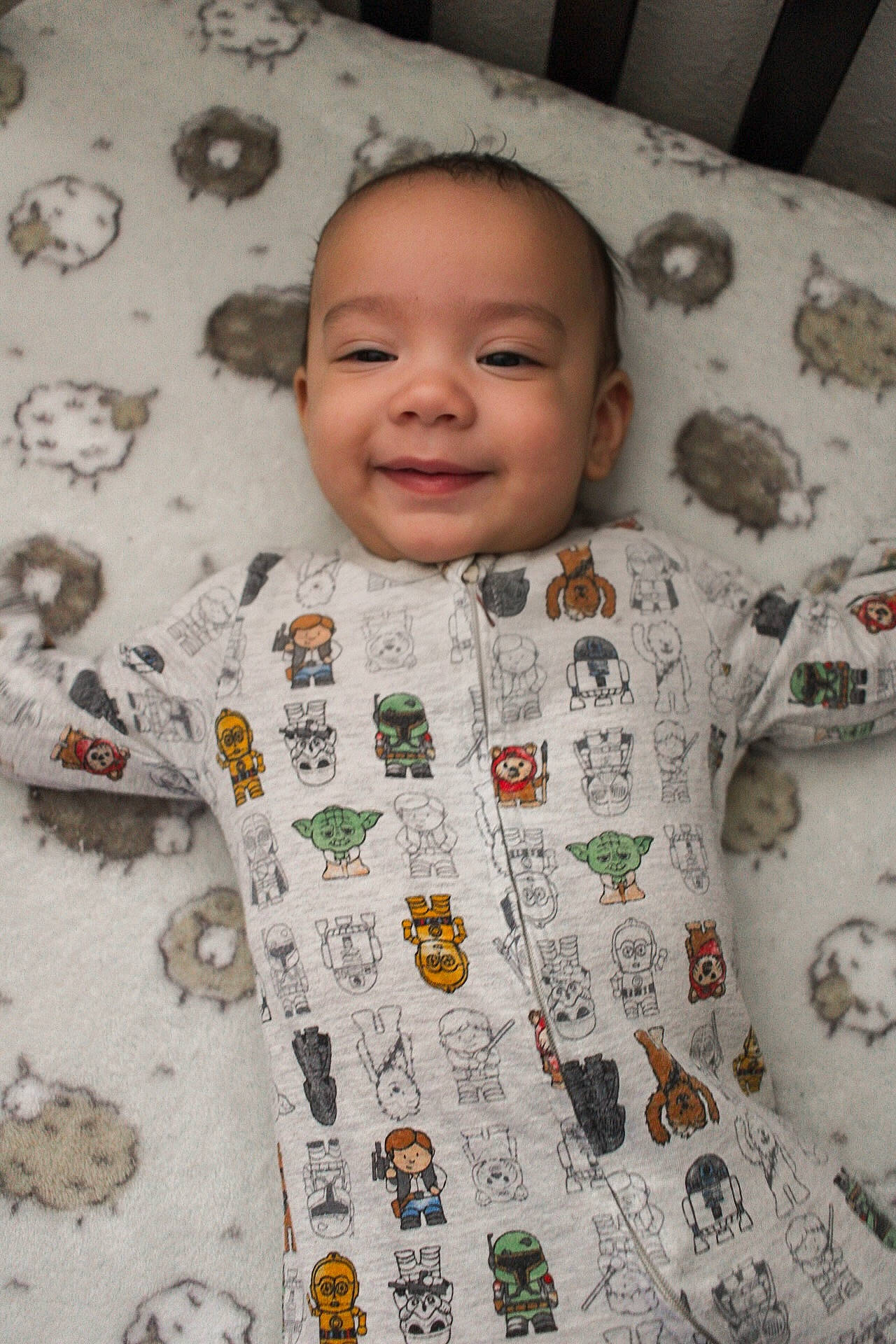 Creed is registered to the contest to win money with this photo: baby, baby_toddler_clothing, child, collar, comfort, eye, face, facial_expression, flooring, fun, happy, head, joy, linens, pattern, person, skin, sleeve, smile, t_shirt