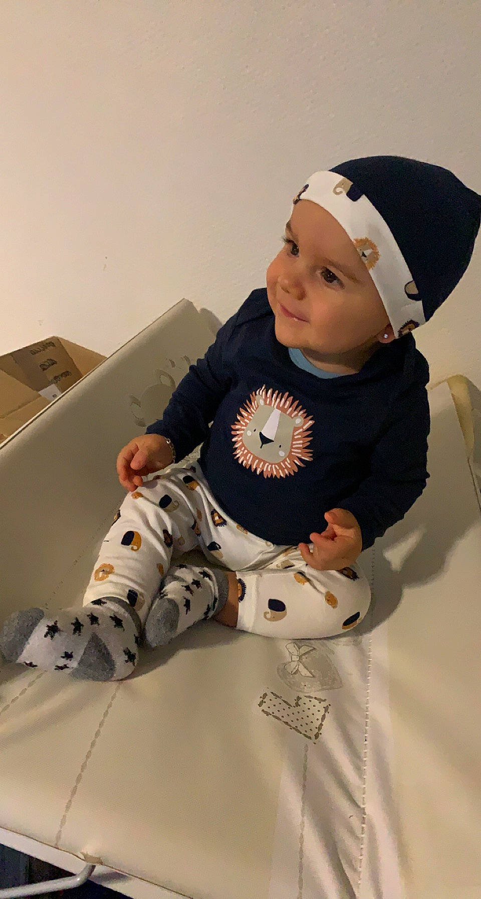 Esteban a rejoint le concours — aidez-le/la à gagner de superbes lots ! baby, baby_toddler_clothing, beanie, box, cap, carmine, carton, child, comfort, costume_hat, fur, hat, headwear, human_body, pattern, person, room, shipping_box, sitting, sleeve