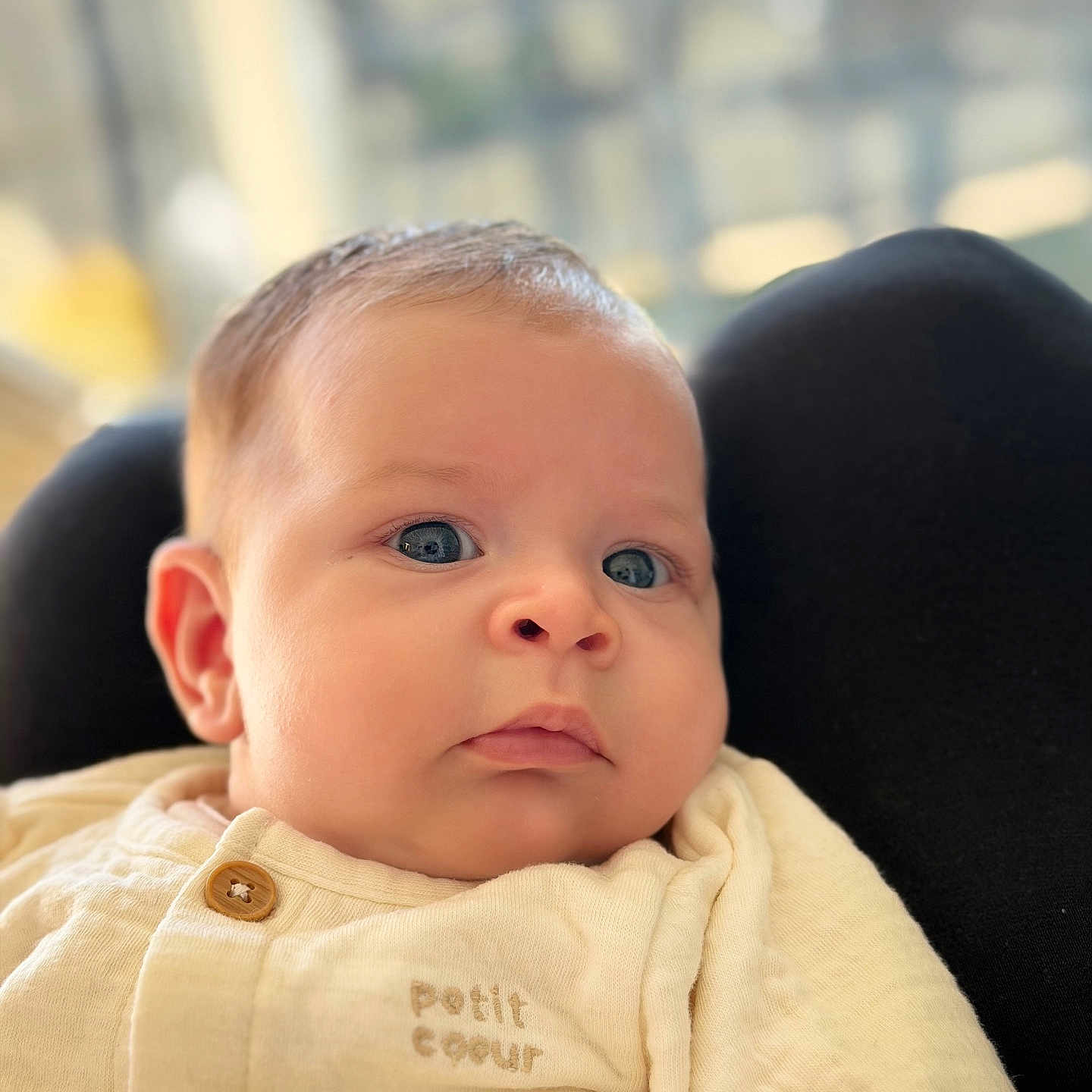 Livia a rejoint le concours — aidez-le/la à gagner de superbes lots ! baby, blue_eyes, blurred_background, button, child, close_up, clothing, cream_outfit, cute, embroidery, expressionless, face, human, indoors, infant, newborn, portrait, resting, soft_skin, young_child