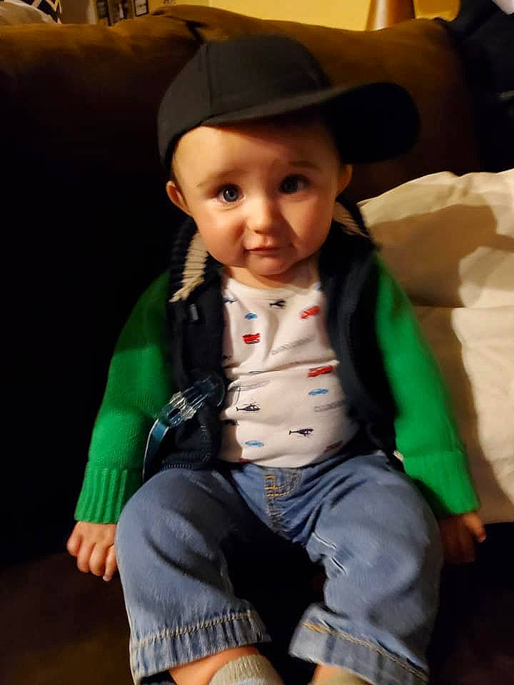 Dillon is registered to the contest to win money with this photo: baby, child, green, hat, headgear, headwear, person, sitting, skin, smile, toddler