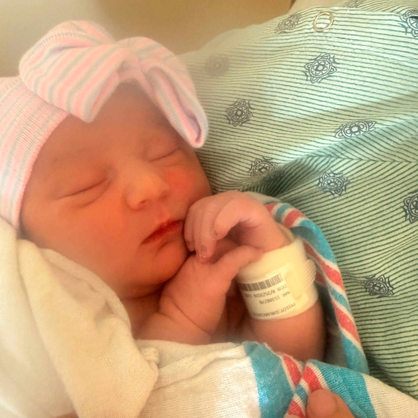 Genoveva is registered to the contest to win money with this photo: newborn, baby, infant, sleeping, hospital, blanket, hat, wristband, hand, person, closeup, cute, peaceful, wrapped, striped, pink, blue, skin, resting, soft