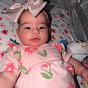 Victoria is registered to the contest to win money with this photo: baby, child, bow, pink_dress, floral_pattern, stuffed_toy, crib, mesh_canopy, face, portrait, cute, infant, sleeping_area, fabric, soft_toy, smile, happy, person, indoors, closeup