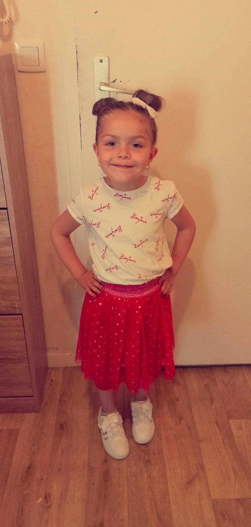 Sharon participe au concours pour gagner de l'argent avec cette photo : baby_toddler_clothing, door, face, floor, flooring, hair, happy, hardwood, human_leg, joy, knee, leg, person, pink, sleeve, smile, standing, toddler, trunk, waist