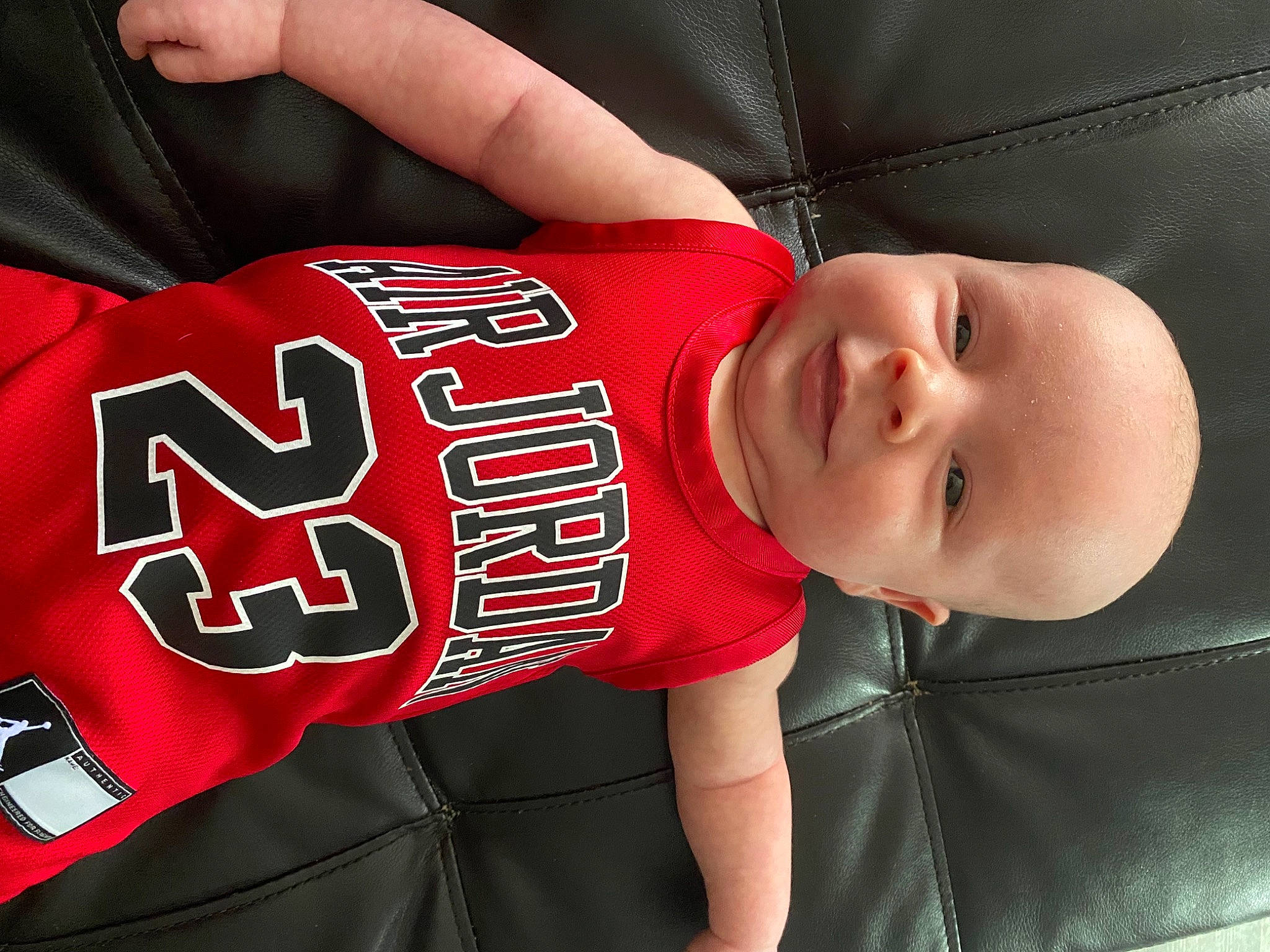 Collin is registered to the contest to win money with this photo: baby, baby_toddler_clothing, carmine, chest, child, comfort, elbow, font, happy, human_leg, jersey, mammal, person, sleeve, sports_jersey, sports_uniform, sportswear, t_shirt, toddler, uniform