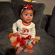 Shanniiya is registered to the contest to win money with this photo: toddler, child, thanksgiving, holiday, festive_clothing, headband, toy, couch, pillow, striped_leggings, orange, white_shirt, bow, indoor, home, cute, sitting, curious, smiling, person