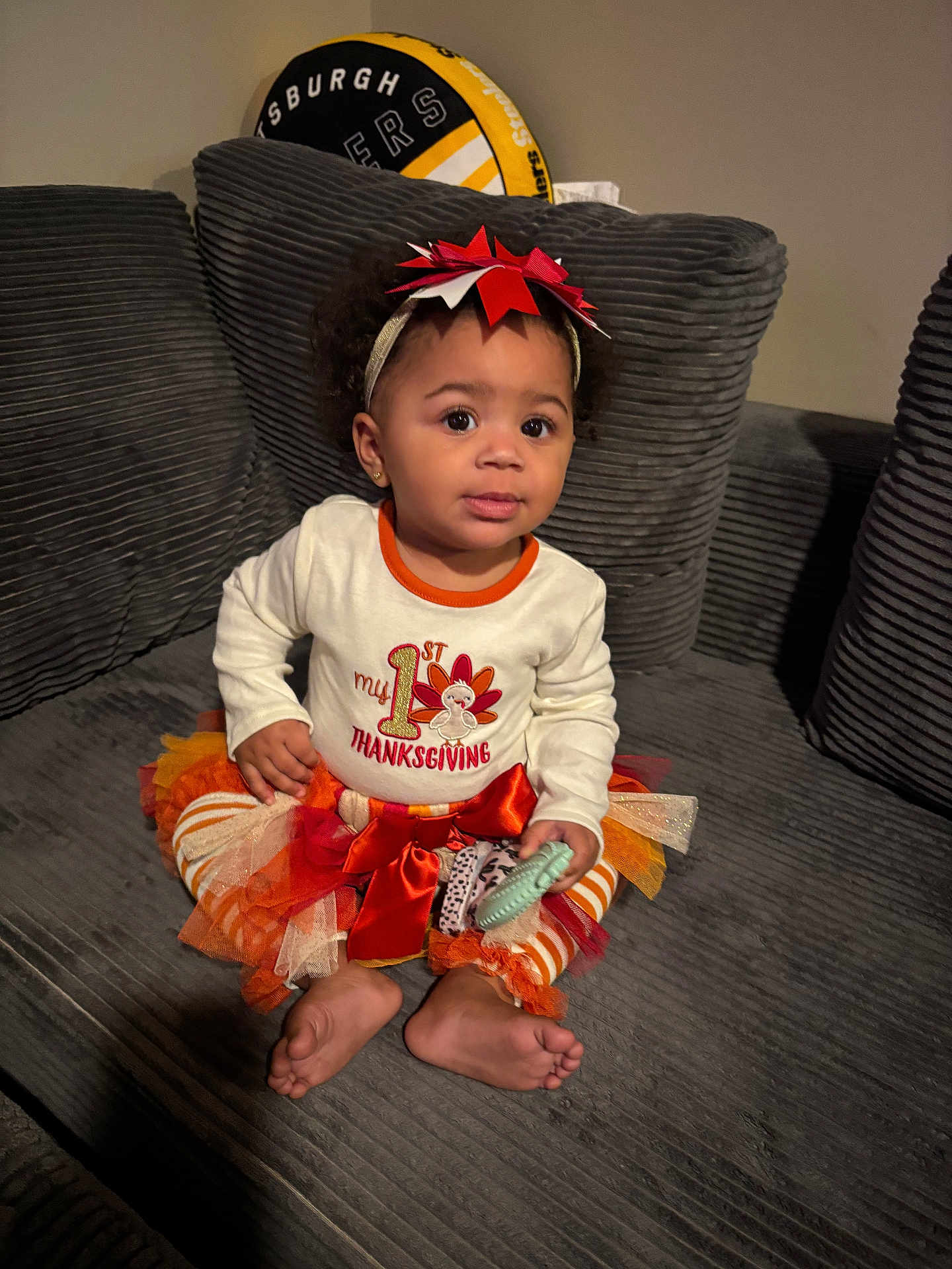 Shanniiya is registered to the contest to win money with this photo: toddler, child, thanksgiving, holiday, festive_clothing, headband, toy, couch, pillow, striped_leggings, orange, white_shirt, bow, indoor, home, cute, sitting, curious, smiling, person