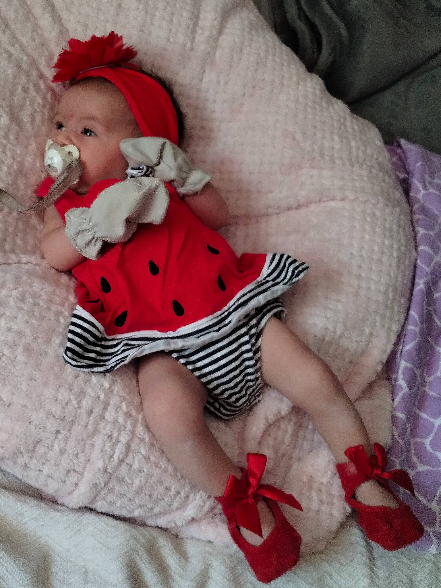 Storm is registered to the contest to win money with this photo: baby, baby_toddler_clothing, child, comfort, costume_hat, doll, dress, hat, head, human_leg, linens, pattern, person, pink, plaid, red, sleeve, sock, textile, thigh