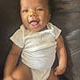 Angel is registered to the contest to win money with this photo: baby, infant, smiling, happy, onesie, white_clothing, sitting, leather_couch, indoor, child, cute, tongue_out, portrait, person, skin, arm, leg, face, young, expression