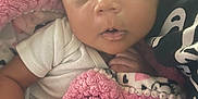 Angel is registered to the contest to win money with this photo: baby, infant, blanket, pink, white_clothing, face, hand, curious, closeup, newborn, texture, soft, cuddly, child, portrait, indoor, fabric, pattern, skin, cute