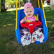Nova joined the competition — help win amazing prizes! baby, child, swing, outdoor, grass, tree, headband, flower, playground, smiling, happy, colorful_clothing, pants, toy, seat, sunlight, nature, yard, rope, person